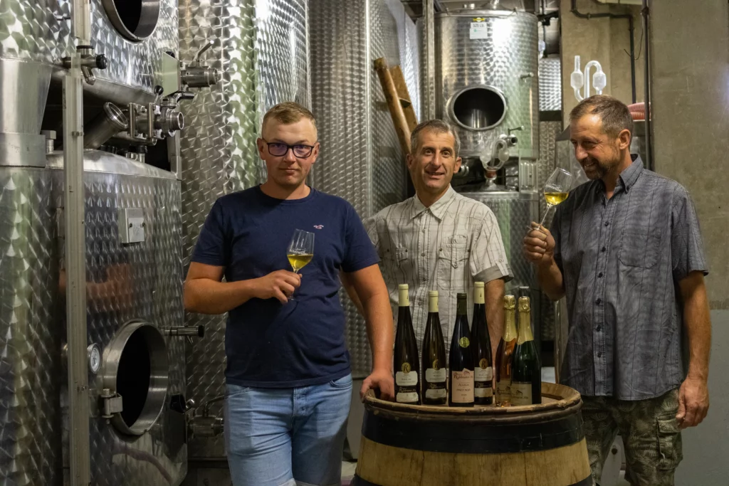 The Ruhlmann winemakers in their winery in Scherwiller, glasses of Alsace wine in hand