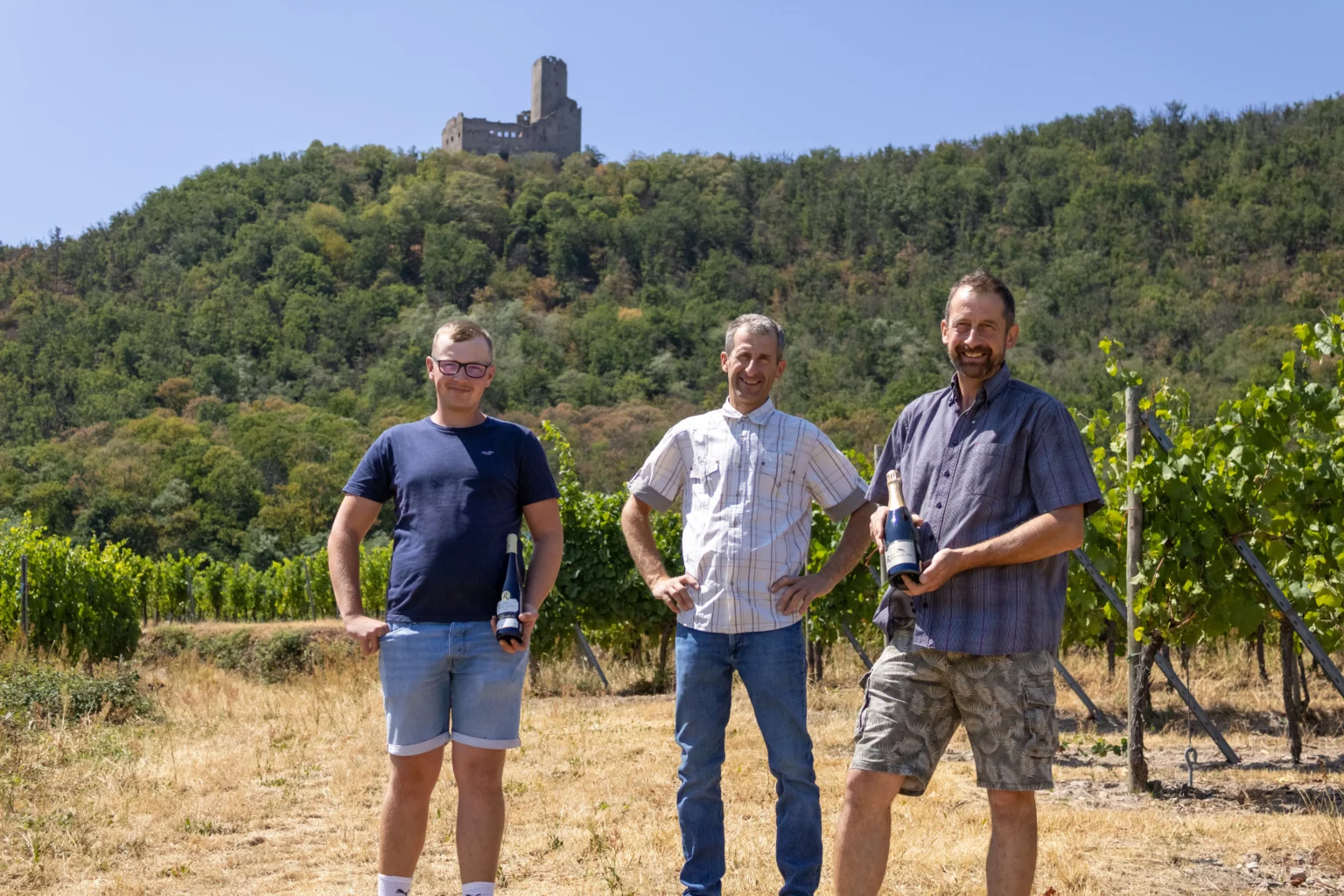 The Gilbert Ruhlmann Fils winemakers with their wines in the Scherwiller vineyard, below Ortenbourg castle